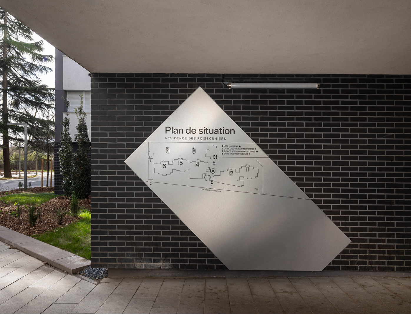 Plan de situation et signalétique intérieure dans le corridor d’entrée d’une résidence parisienne avec design graphique sur mesure.