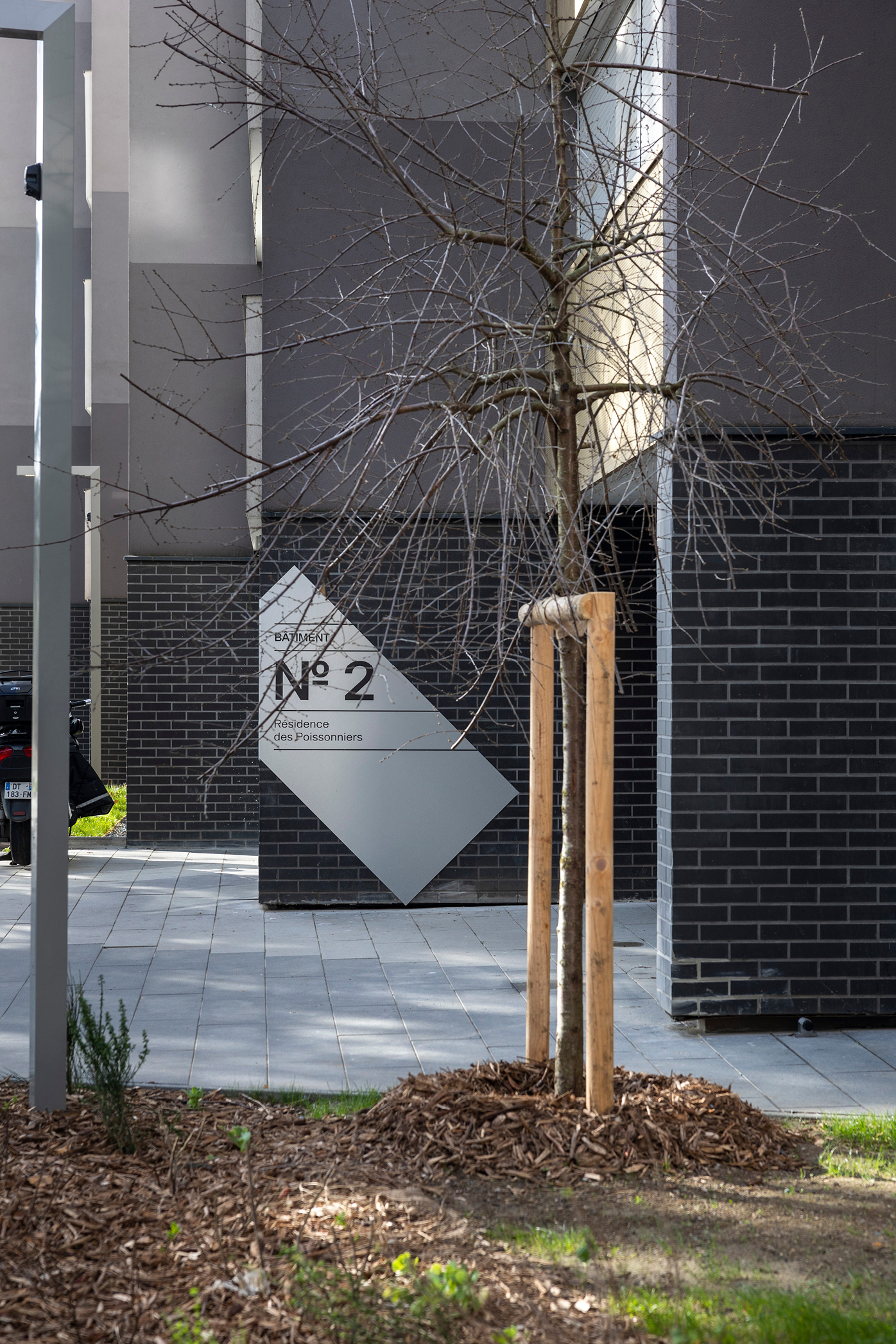 Signalétique intérieure personnalisée dans une résidence parisienne avec intégration dans un espace arboré et design moderne