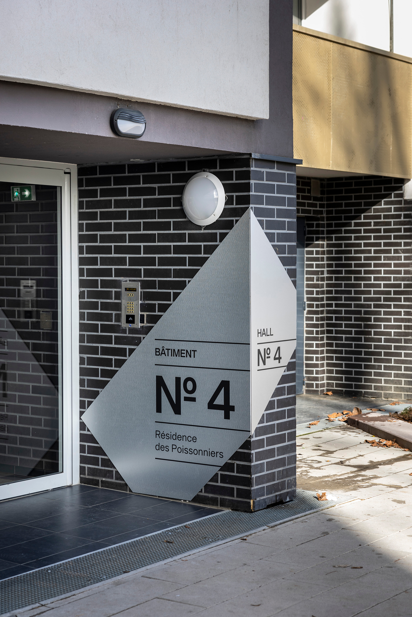 Signalétique intérieure sur mesure dans une résidence parisienne arborée avec design graphique moderne et intégration harmonieuse.