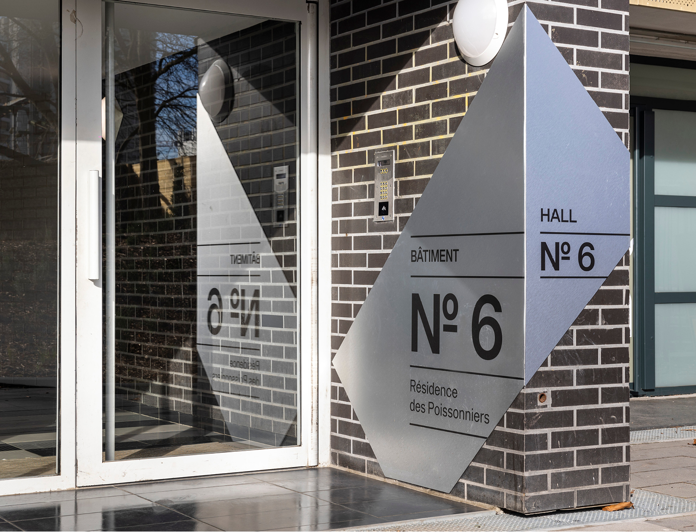 Signalétique intérieure sur mesure dans une résidence parisienne arborée avec design graphique contemporain et lisibilité optimale.